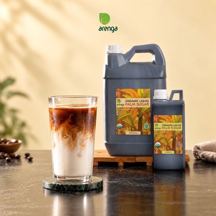 Foto profesional dirty latte gula aren dalam gelas bening, dengan espresso di atas susu dingin, ditemani produk gula aren cair Arenga kemasan besar dan kecil.